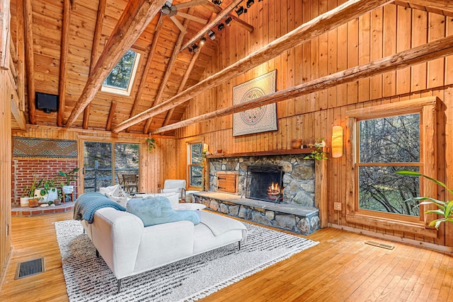 79 Torre Rock Rd, Red Hook, NY 12571 - living room with high vaulted ceiling, wood walls, a fireplace, a wooden ceiling with exposed beams, and wood-type flooring
