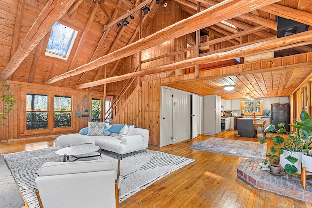 79 Torre Rock Rd, Red Hook, NY 12571 - living area featuring a skylight, wood walls, a wood ceiling with exposed beams, high vaulted ceiling, and light wood-style flooring