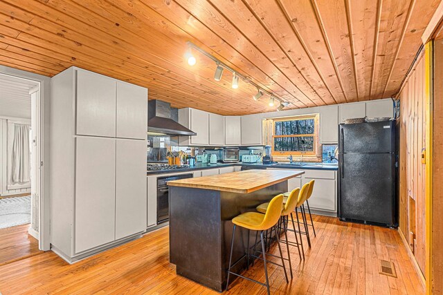 79 Torre Rock Rd, Red Hook, NY 12571 - kitchen featuring freestanding refrigerator, wall chimney range hood, butcher block counters, wall oven, and light wood-type flooring