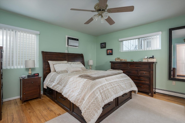 720 W Park Ave, Long Beach, NY 11561 - bedroom featuring baseboard heating, light wood-style flooring, a wall unit AC, and ceiling fan