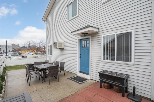 720 W Park Ave, Long Beach, NY 11561 - view of exterior entry with a wall mounted air conditioner, a patio, outdoor dining area, and fence