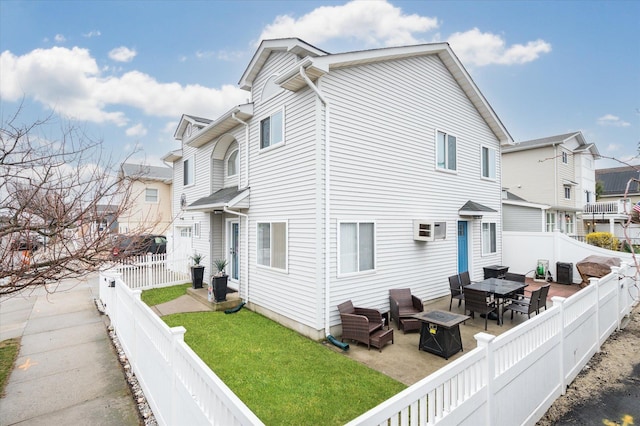 720 W Park Ave, Long Beach, NY 11561 - rear view of property featuring a fenced backyard, a lawn, an AC wall unit, a fire pit, and a residential view