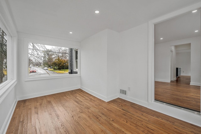 spare room with recessed lighting, baseboards, visible vents, and wood finished floors