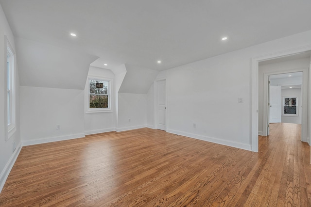 additional living space with light wood-style flooring, baseboards, lofted ceiling, and recessed lighting