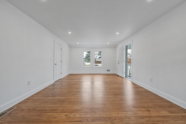 spare room featuring baseboards, visible vents, wood finished floors, and recessed lighting