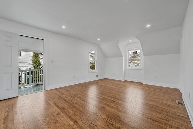 bonus room featuring wood finished floors, plenty of natural light, vaulted ceiling, and visible vents