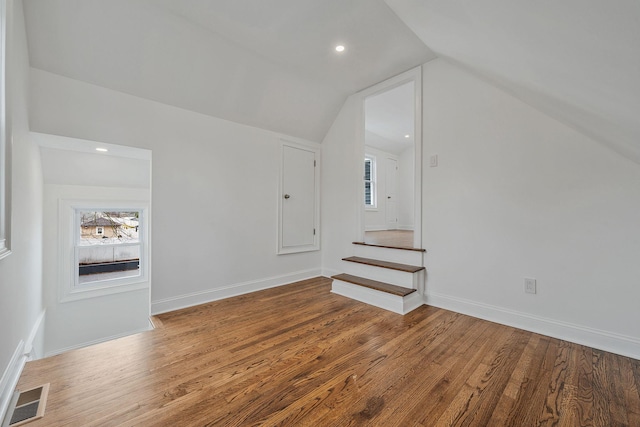 bonus room featuring visible vents, baseboards, wood finished floors, stairway, and lofted ceiling