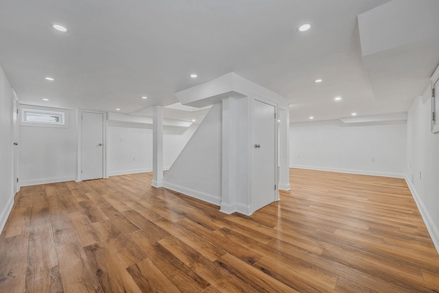 finished basement featuring baseboards, recessed lighting, and light wood-type flooring