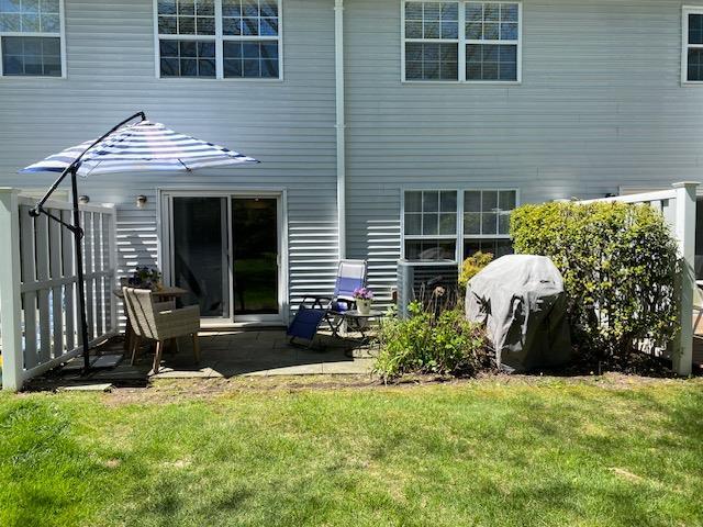 rear view of house featuring a lawn and a patio area