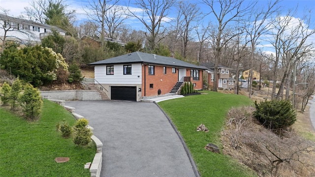 view of front of property with a garage, a front yard, stairs, and aphalt driveway
