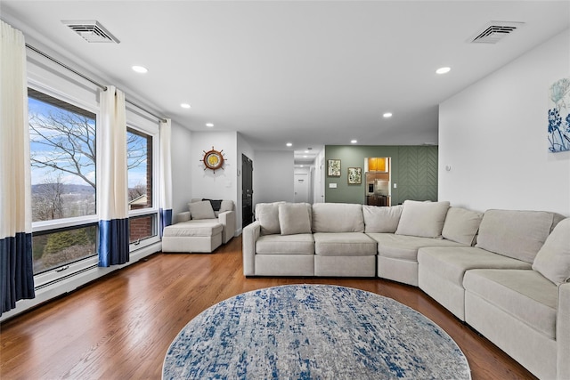 living room with wood finished floors, visible vents, and recessed lighting