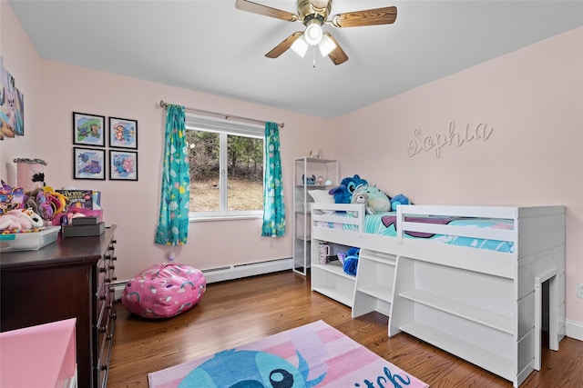 bedroom featuring a baseboard radiator, wood finished floors, and ceiling fan