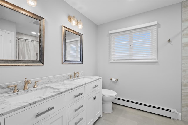 bathroom featuring a baseboard heating unit, toilet, a sink, and double vanity