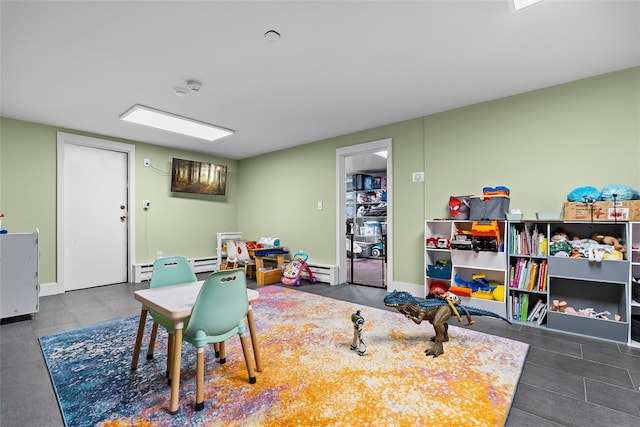recreation room with tile patterned flooring and a baseboard radiator