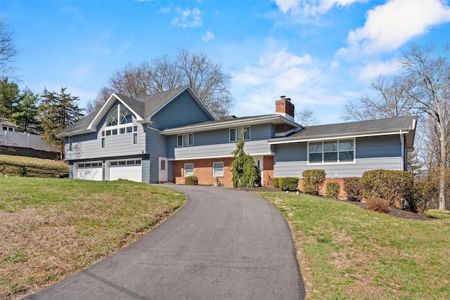 view of front of house with a garage, aphalt driveway, brick siding, and a front yard