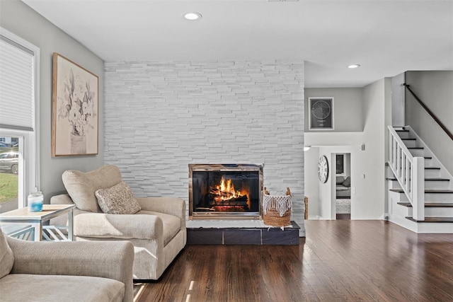 living room with wood finished floors, recessed lighting, a fireplace, and stairway
