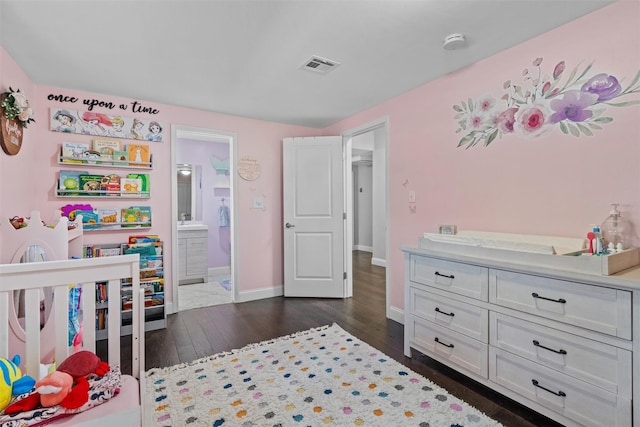 bedroom with visible vents, baseboards, a sink, and dark wood finished floors