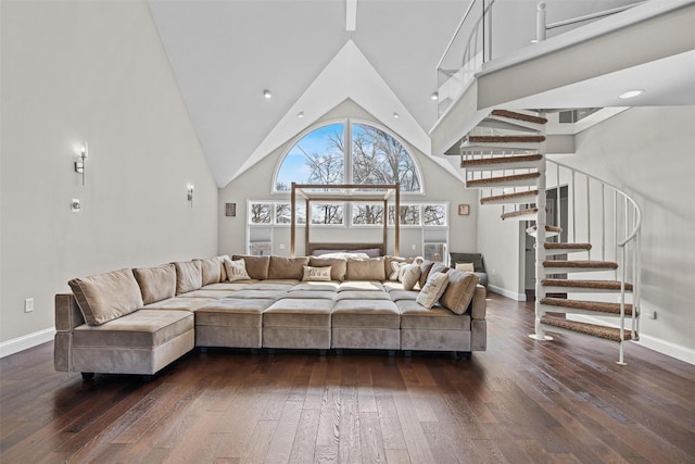 living room featuring dark wood-type flooring, baseboards, high vaulted ceiling, and stairway
