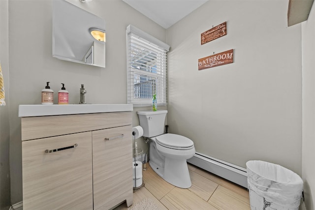 half bathroom with toilet, vanity, and baseboard heating