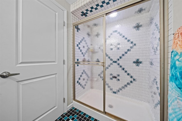bathroom with a shower stall and tile patterned flooring