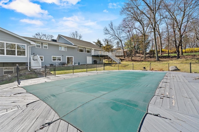 view of swimming pool featuring a yard, a deck, fence private yard, and stairs
