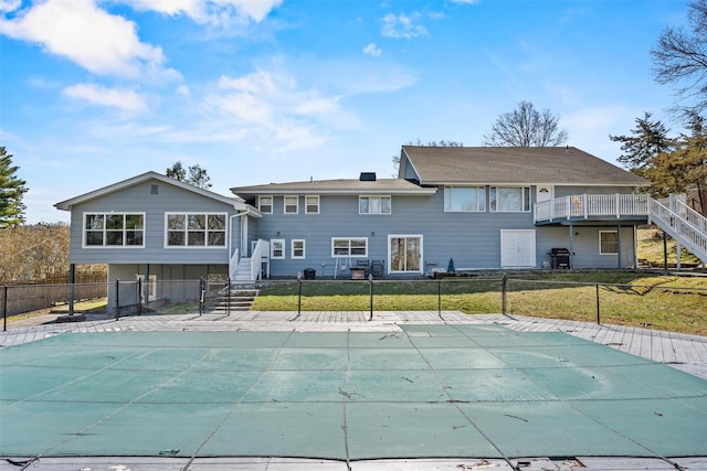 back of property featuring a yard, fence, stairway, a patio, and a fenced in pool