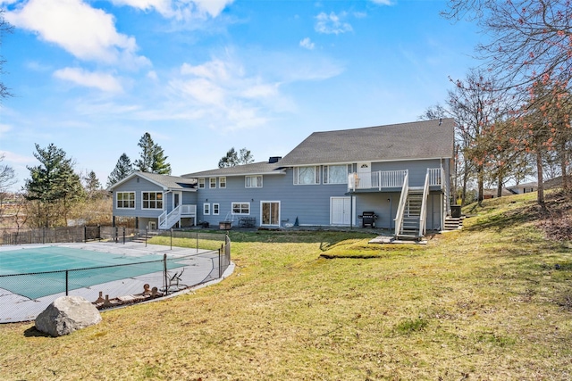 view of pool featuring a lawn, fence, stairway, a wooden deck, and a fenced in pool