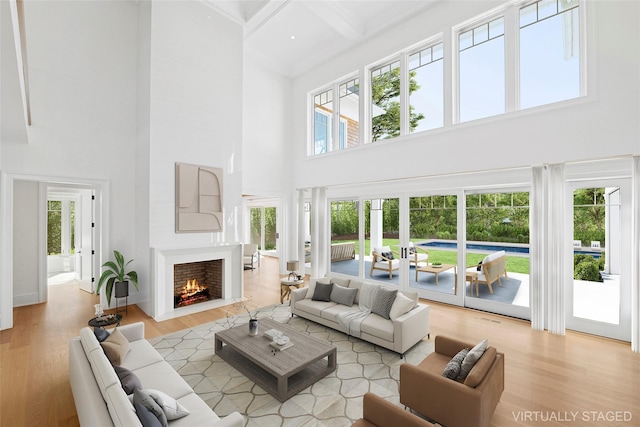 25 Fresh Pond Rd, North Haven, NY 11963 - living area featuring a lit fireplace, wood finished floors, and plenty of natural light