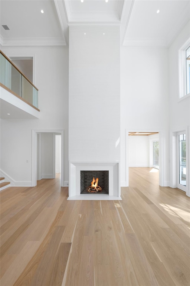 25 Fresh Pond Rd, North Haven, NY 11963 - unfurnished living room with light wood-style flooring, ornamental molding, and a high ceiling