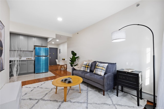 living area with light wood finished floors, baseboards, and recessed lighting