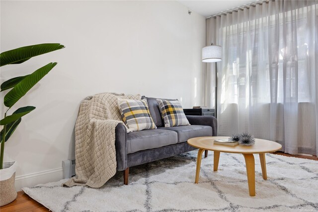 living area with baseboards and wood finished floors
