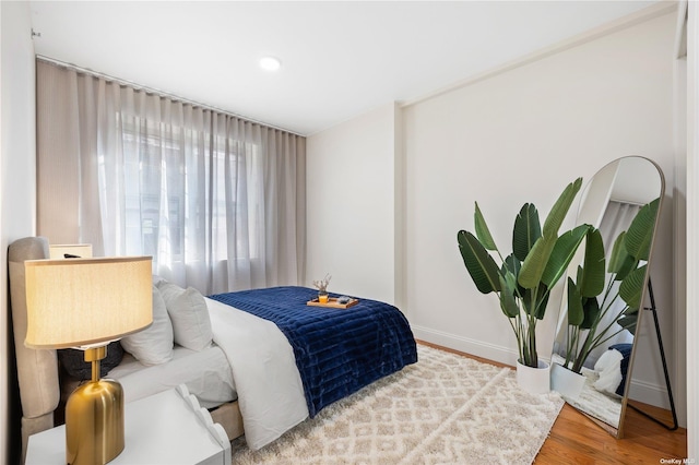 bedroom featuring baseboards and wood finished floors