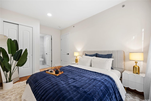 bedroom featuring ensuite bathroom, a closet, wood finished floors, and recessed lighting