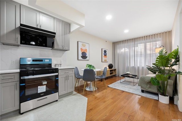 kitchen featuring light countertops, recessed lighting, stainless steel range oven, light wood-type flooring, and gray cabinetry