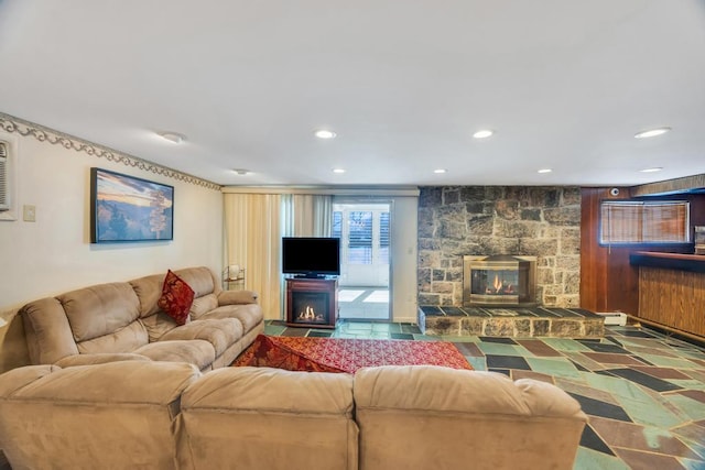 living room featuring recessed lighting and a stone fireplace