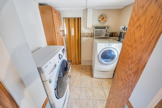 clothes washing area featuring light tile patterned floors, a wall unit AC, and washing machine and clothes dryer