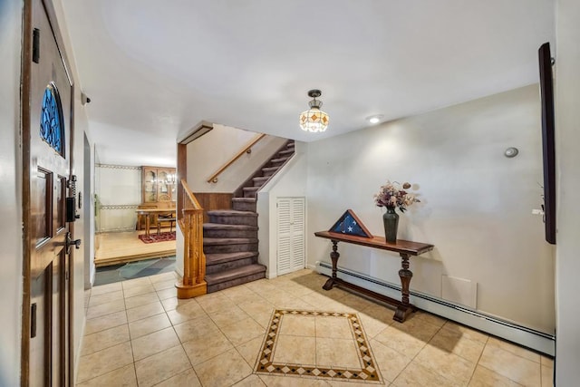 entryway with tile patterned floors, a baseboard radiator, and stairs