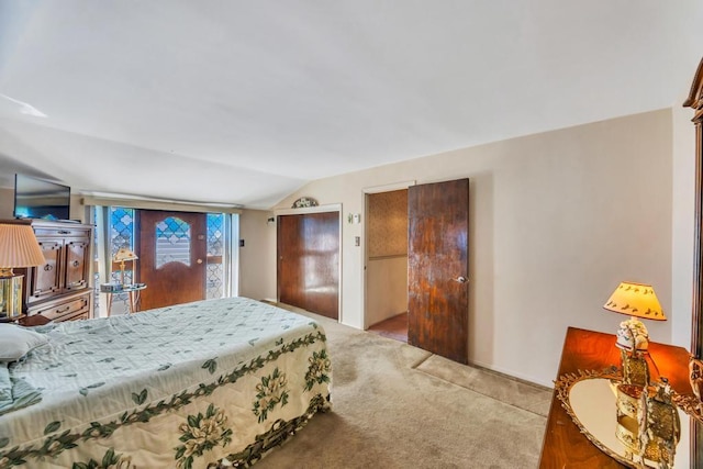 carpeted bedroom with lofted ceiling