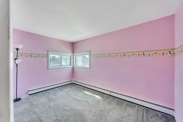 carpeted spare room with a baseboard heating unit