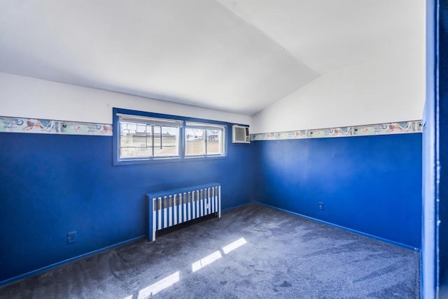 carpeted empty room with a wall mounted AC, lofted ceiling, and radiator heating unit