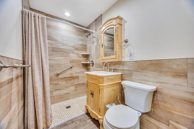 full bath featuring vanity, wood finished floors, toilet, tile walls, and tiled shower