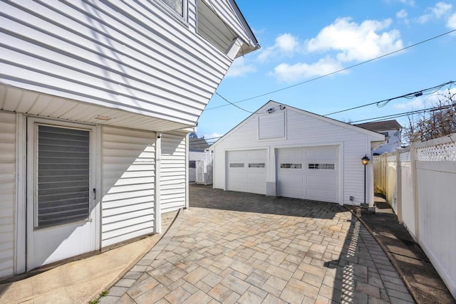 detached garage featuring fence