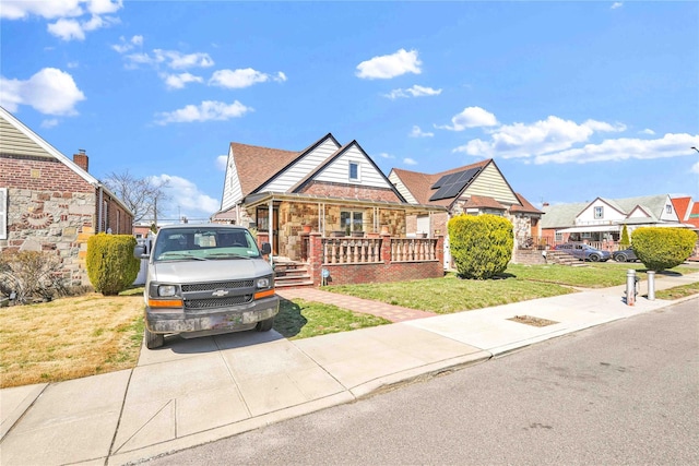 183-65 Elmira Ave, Saint Albans, NY 11412 - view of front of home with a front yard, a porch, and stone siding