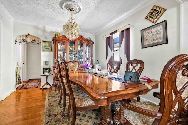 183-65 Elmira Ave, Saint Albans, NY 11412 - dining space featuring a textured ceiling, crown molding, wood finished floors, and an inviting chandelier