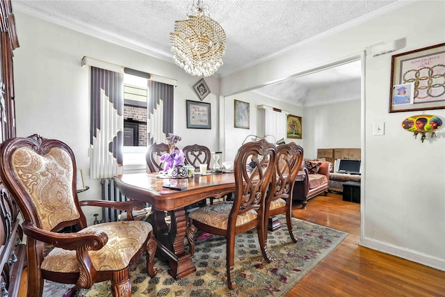 183-65 Elmira Ave, Saint Albans, NY 11412 - dining space with an inviting chandelier, crown molding, a textured ceiling, and wood finished floors