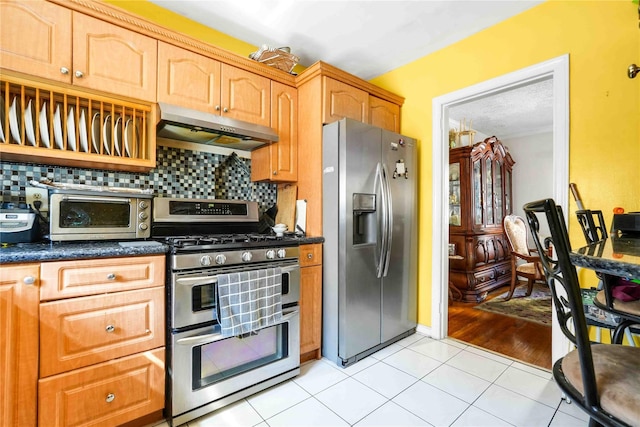 183-65 Elmira Ave, Saint Albans, NY 11412 - kitchen with light tile patterned floors, stainless steel appliances, under cabinet range hood, a toaster, and decorative backsplash