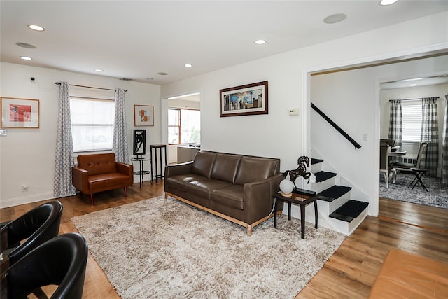 living area with baseboards, recessed lighting, wood finished floors, and stairway