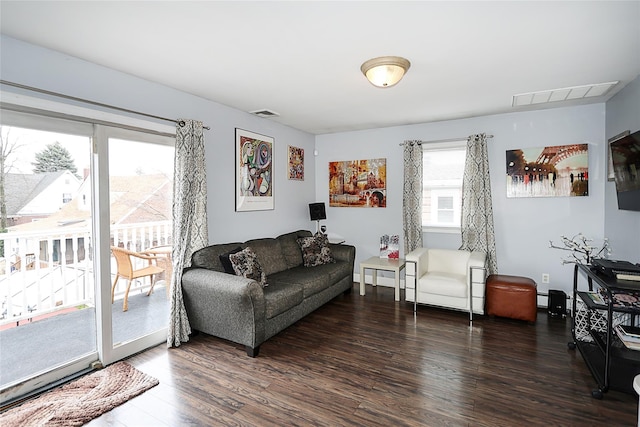 living room featuring visible vents, wood finished floors, and baseboard heating