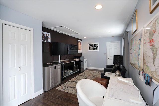 living area featuring dark wood-type flooring, baseboards, recessed lighting, and attic access