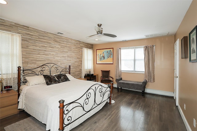 bedroom with baseboards, visible vents, baseboard heating, and dark wood-style flooring